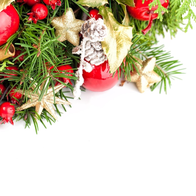 Borde de fondo de Navidad. Ramita de árbol de Navidad, estrella dorada, bolas de Navidad y bayas rojas sobre fondo blanco.