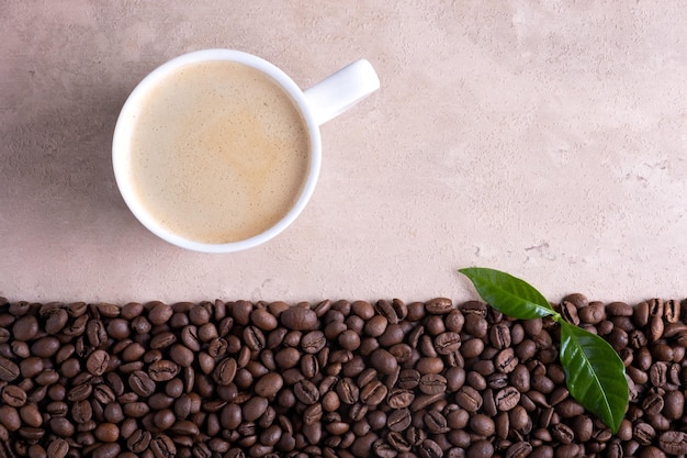 Borde de granos de café tostado y taza de café