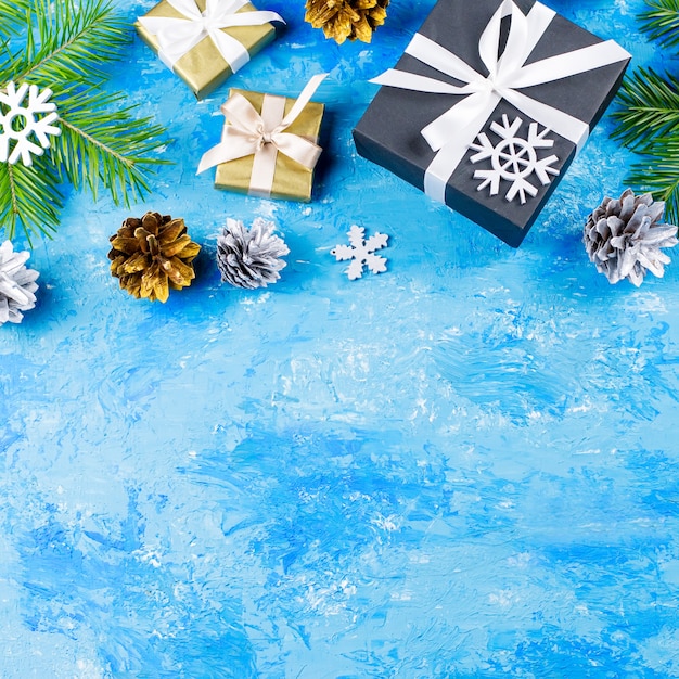 Borde de Navidad azul con ramas de abeto, cajas de regalo, adornos plateados y dorados, espacio de copia