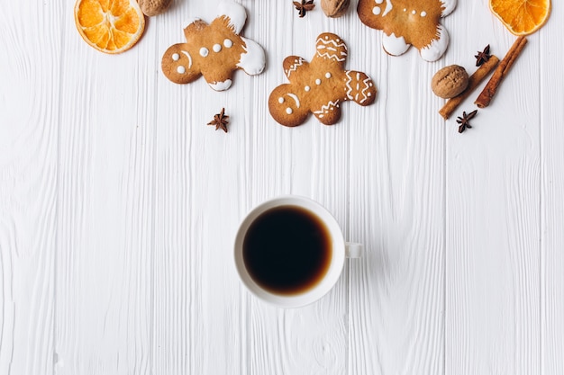 Borde de Navidad. Galletas de jengibre, especias y decoraciones sobre fondo blanco de madera.