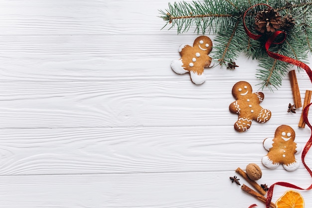 Borde de Navidad. Galletas de jengibre, especias y decoraciones sobre fondo blanco de madera.