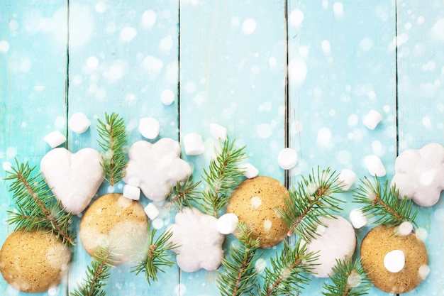 Borde navideño con malvavisco de pan de jengibre y rama de abeto decorado con nieve