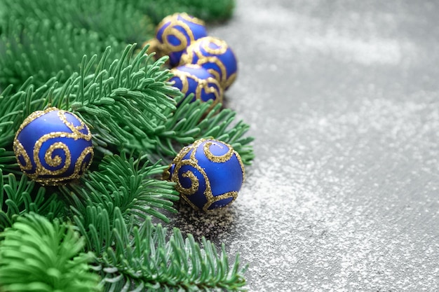 Borde navideño de ramas de abeto y adornos de bolas azules brillantes con espacio para copiar saludos