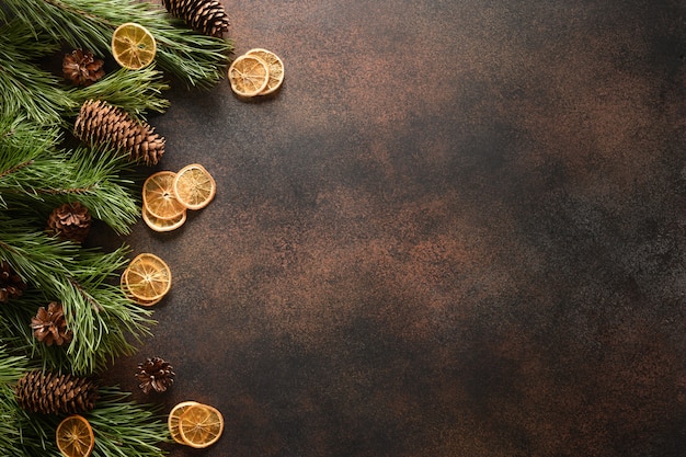 Borde navideño con rodajas de naranja aroma canela abeto y conos