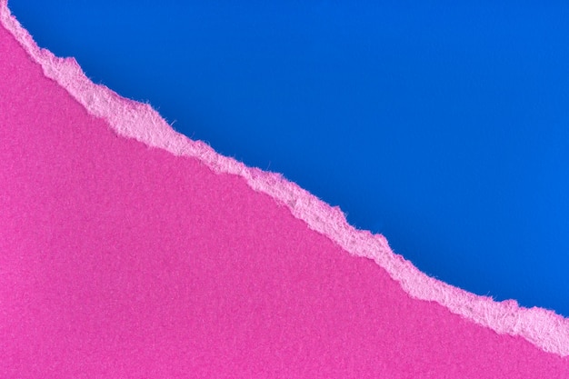 Borde de papel púrpura rasgado sobre fondo azul. Borde de la pieza de papel rasgado aislado con sombra suave. Copia espacio
