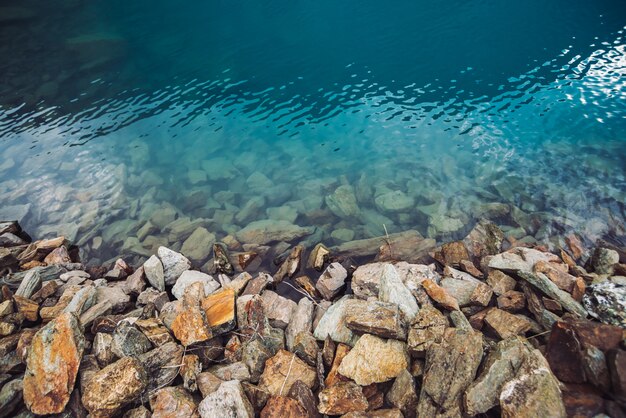 Borde pedregoso del lago de montaña azul