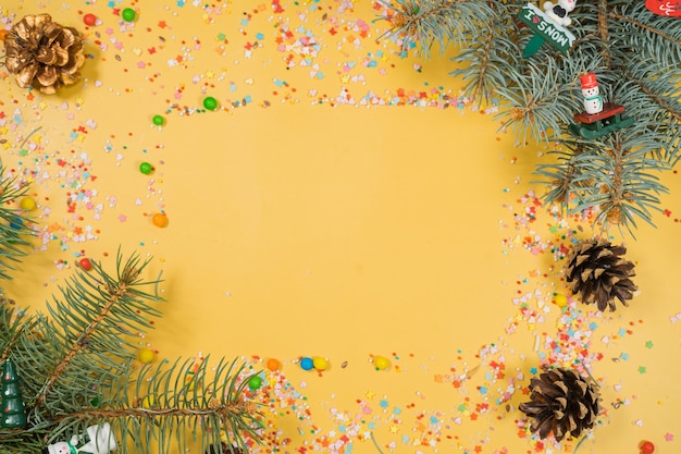 Borde de ramas de abeto de decoración de Navidad sobre fondo amarillo bueno para telón de fondo de Navidad