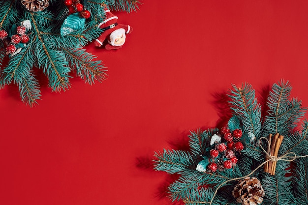 Borde de ramas de abeto sobre fondo rojo bueno para el telón de fondo de Navidad