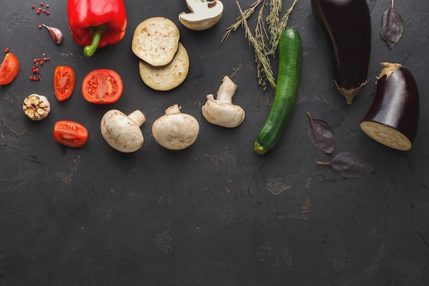 Borde de varias verduras sobre fondo oscuro, vista superior con espacio de copia