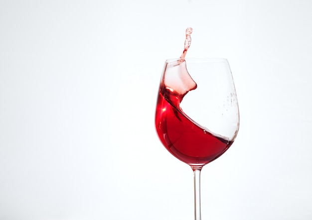 Bordeauxwein im Glas auf einem weißen Hintergrund. Das Konzept von Getränken und Alkohol.