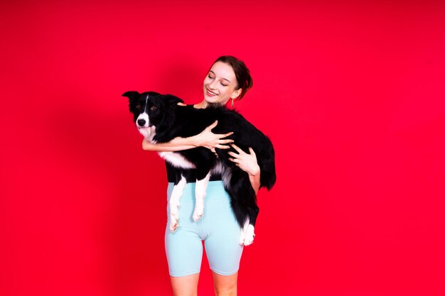 Foto border collie-hund und sport-fitness-frau vor gelb-rotem hintergrund