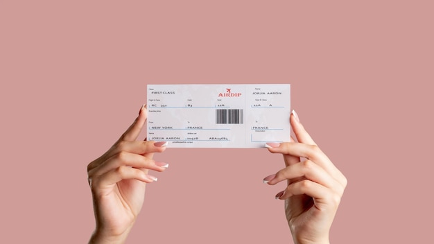 Bordkarte Internationaler Flug Passagierin Hände halten First-Class-Ticket isoliert auf blassrosa Kopierraum Weltreisen Urlaubsreise Geschäftsreise Check-in am Flughafen