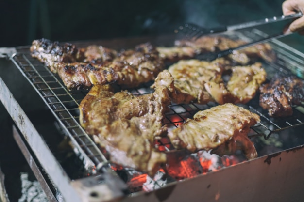 Borradas de homens asiáticos estão cozinhando churrasco