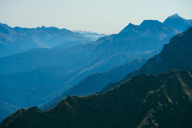 Borrado abstrato natural com montanhas em uma névoa azul matinal