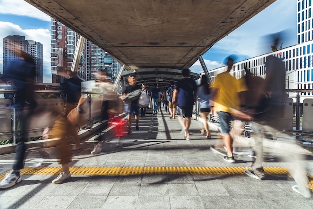 Borrão de movimento de pessoas asiáticas lotadas andando na passarela pública elevada