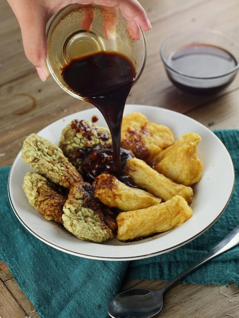 borrar comida Pempek sendo encharcada em molho preto, comida indonésia