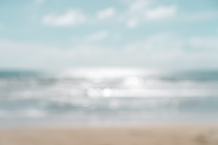 Foto borre a praia do bokeh do verão com luz do sol e o céu azul.