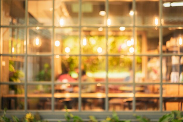 Borrosa de café (restaurante) con luz dorada en la noche. Para un estilo de vida moderno.