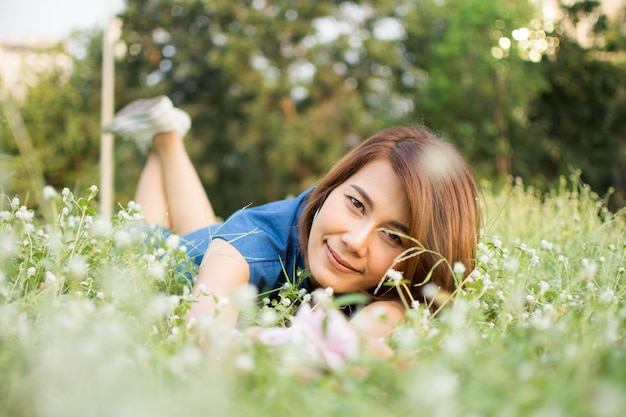 borrosa de mujer que se siente feliz en el jardín de flores.