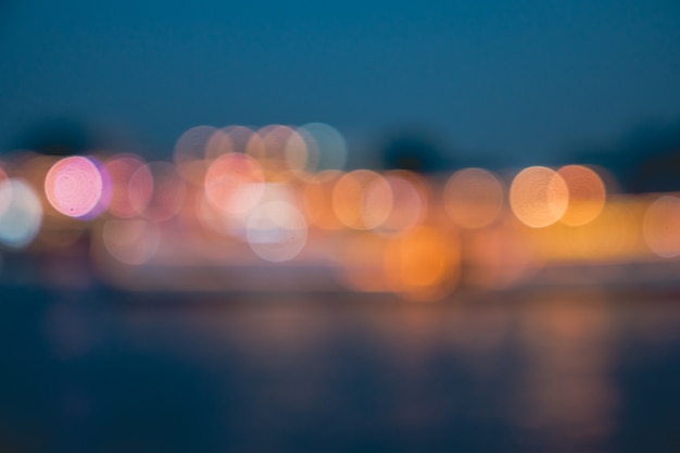Borrosas luces de la ciudad con efecto bokeh reflejadas en el agua