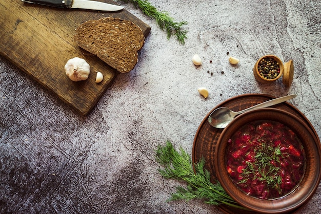 Borsch com pão fresco e endro em uma tigela de barro 2