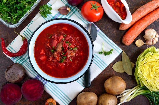 Borsch é um prato tradicional ucraniano em uma tigela e produtos para a sua preparação. Vista superior, plana leigos.