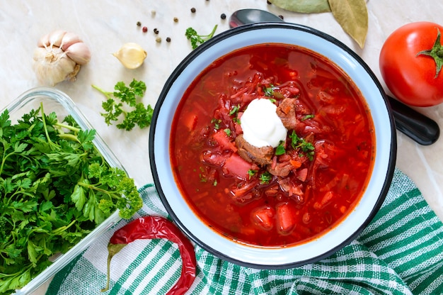 Borsch es un plato tradicional ucraniano en un recipiente sobre la mesa. Almuerzo sabroso y saludable. Vista superior, endecha plana.