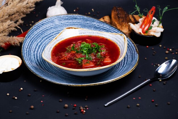 Borsch plato nacional ucraniano con pan oscuro y ajo sobre una superficie oscura