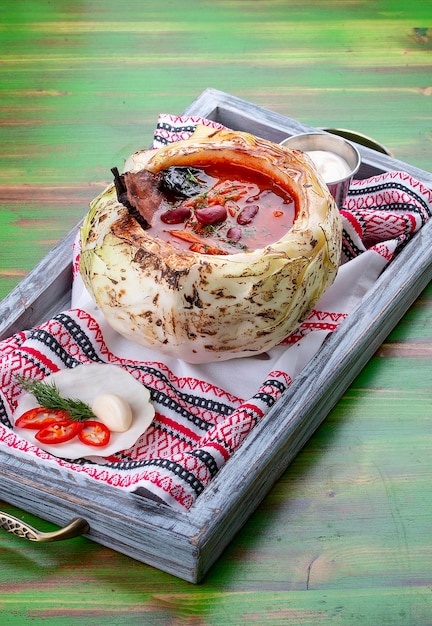 Borscht com feijão cogumelos porcini e ameixas Sobre um fundo de madeira colorida Cozinha russa Prato vegetariano