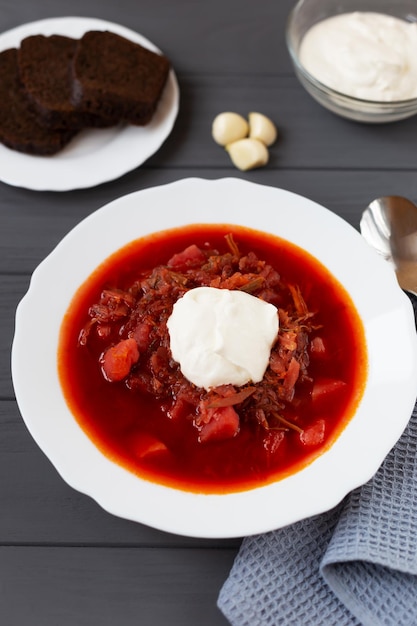 Borscht en un plato sobre un fondo gris