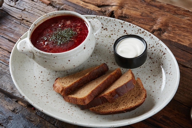 Borscht russo ucraniano tradicional com feijão branco na tigela Prato de sopa de raiz de beterraba vermelha borsch na mesa rustick preta Sopa de beterraba Vista superior Cozinha de comida tradicional da Ucrânia