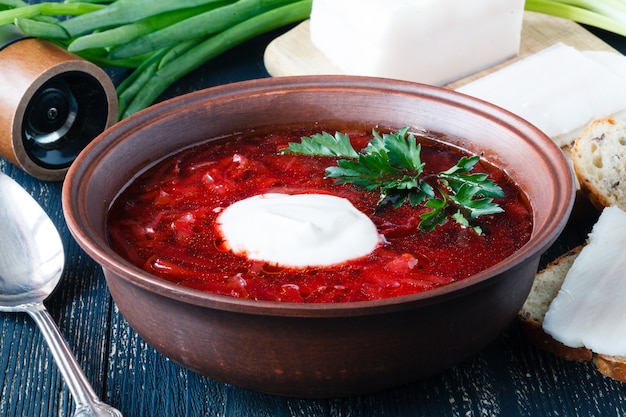 Borscht, sopa de beterraba vegetariana e ingredientes na superfície escura, close-up vista