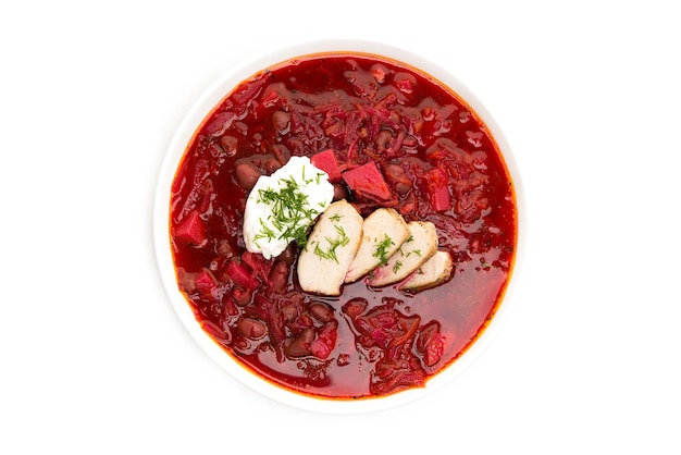 Borscht tradicional com beterraba, carne, feijão, creme de leite e ervas isoladas em um fundo branco, jantar quente, vista de cima