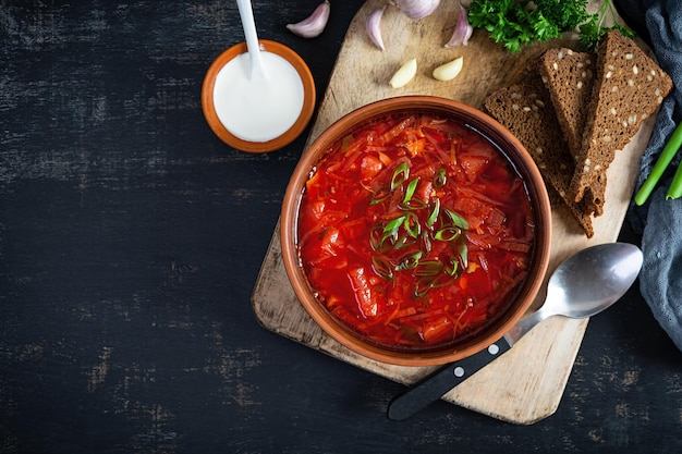 Borscht ucraniano tradicional com cebola verde e creme de leite deliciosa sopa de beterraba em tigela com pão de centeio vista superior