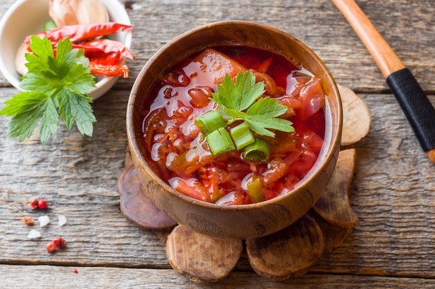 Borschtsch, Rote-Bete-Wurzeln Suppe in einer Holzschale mit frischen Kräutern