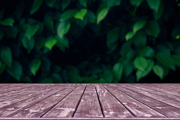 Bosquejo. Mesa cubierta de madera vacía con espacio de follaje bokeh.