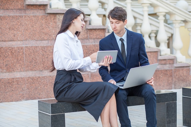 Boss e seu assistente discutindo seu trabalho ao ar livre