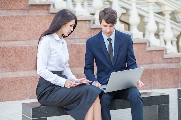 Boss e seu assistente discutindo seu trabalho ao ar livre