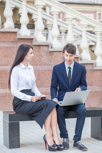 Boss e seu assistente discutindo seu trabalho ao ar livre