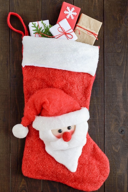 Foto bota de natal para presentes com um papai noel cheio de caixas de presente