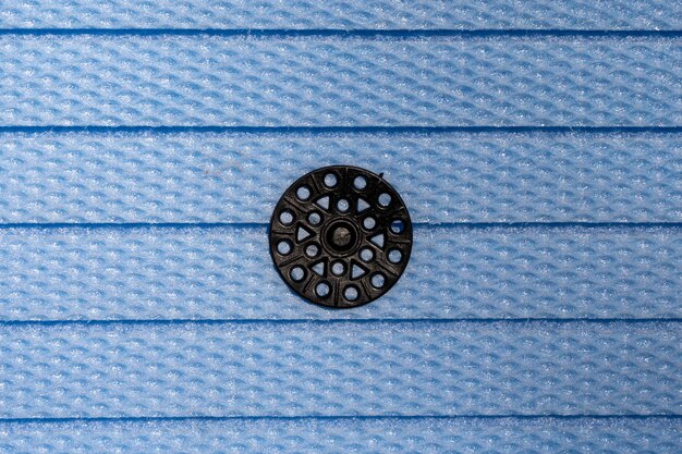 Botão de fixação preto em fundo azul de placa de espuma xps