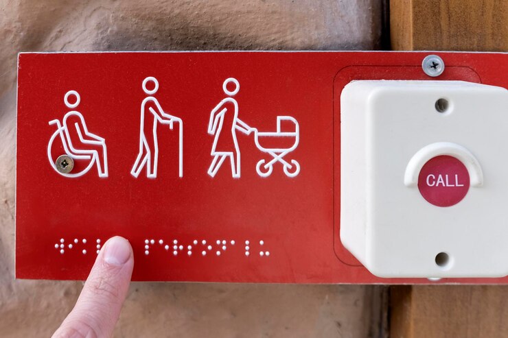 Foto botão para pedir ajuda para pessoas com deficiência idosos e mães com carrinhos placa com a inscrição braille