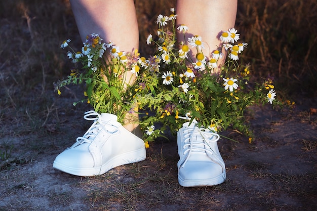 Botas blancas de mujer con ramo de flores