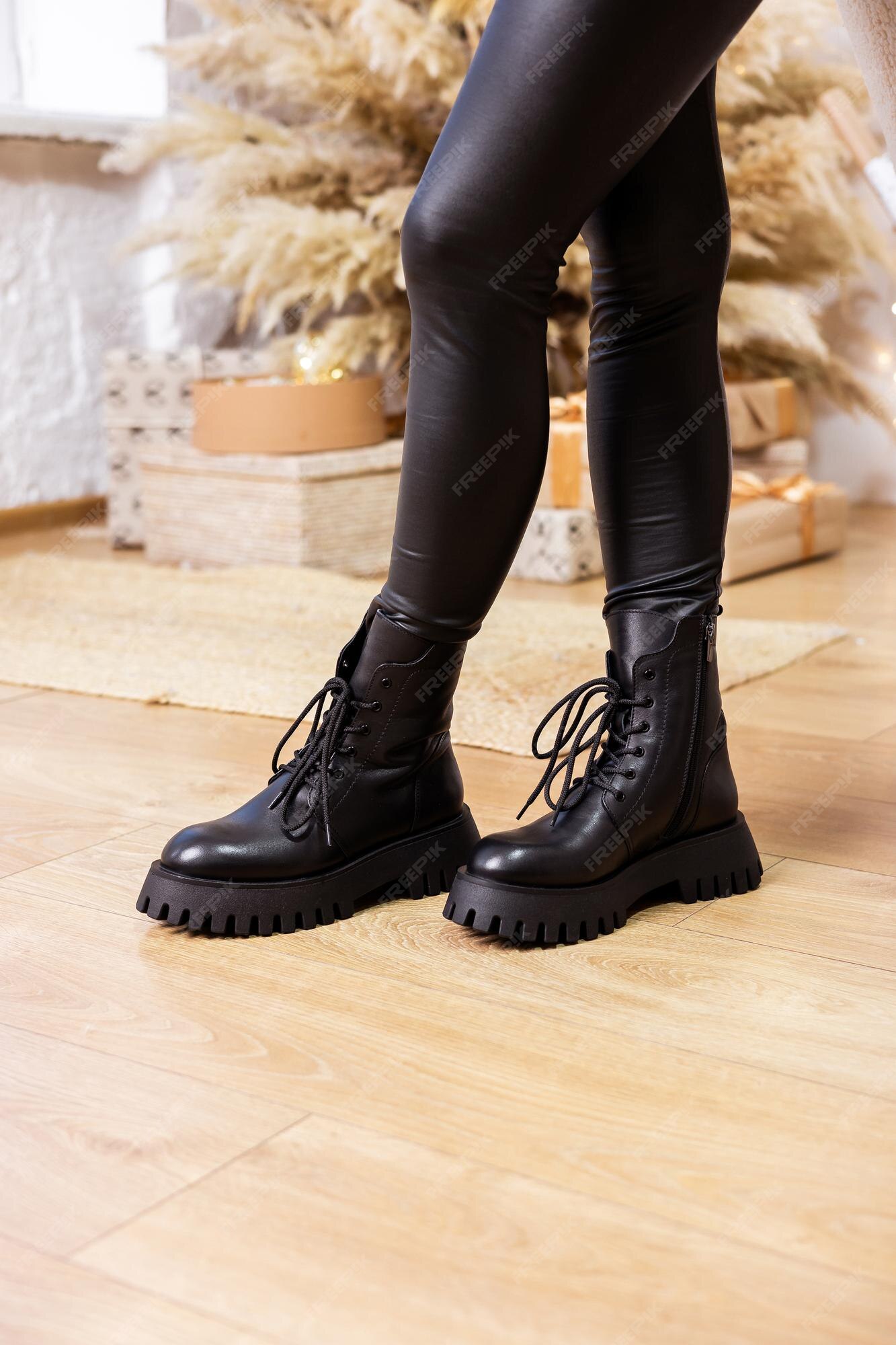 Botas de cuero negro de invierno para con piernas sobre un fondo de nueva colección de zapatos para damas elegantes | Foto Premium