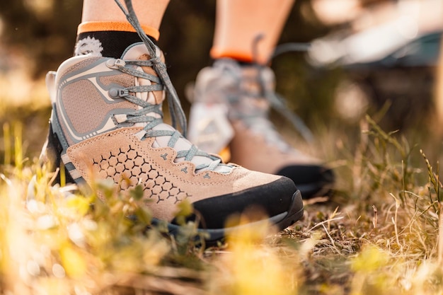 Botas de alpinista trekking nas montanhas na grama Montanhas paisagem viagem estilo de vida Viagem de verão aventura ao ar livre