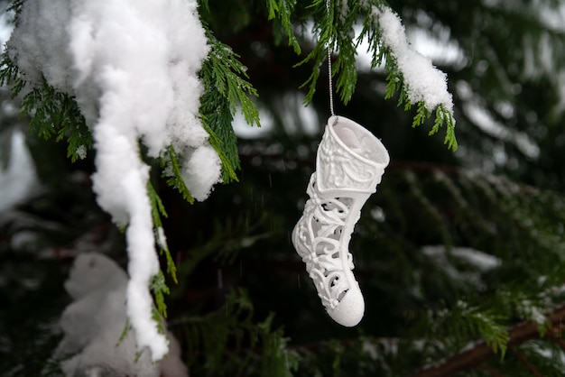 Botas de brinquedo de ano novo penduradas em uma árvore de Natal.