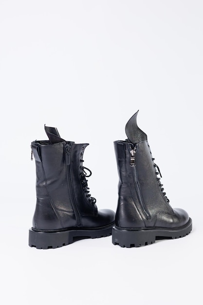 Botas de couro femininas negras da nova coleção em um fundo branco de couro outono-inverno 2022.