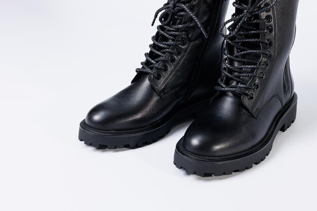 Botas de couro para mulheres negras da nova coleção em um fundo branco de couro outono-inverno 2022.