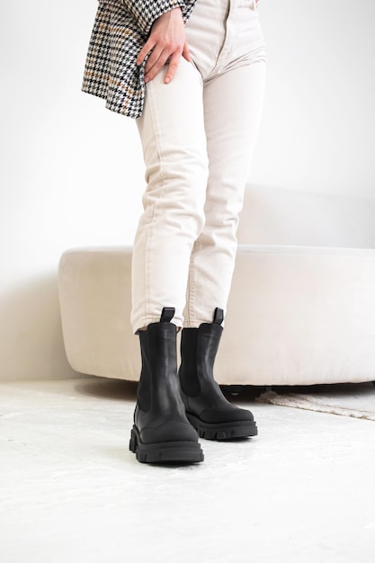 Botas de inverno confortáveis para mulher. Estilo casual para todos os dias. Tiro do estúdio. Menina da moda em calça branca e foto de jaqueta