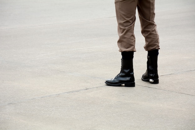 Botas de soldado em pé na estrada em urbana